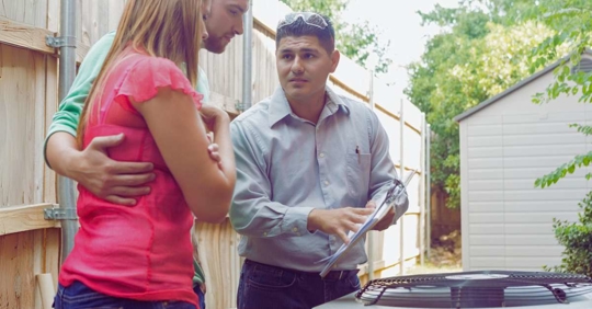 Technician explaining HVAC system to homeowners